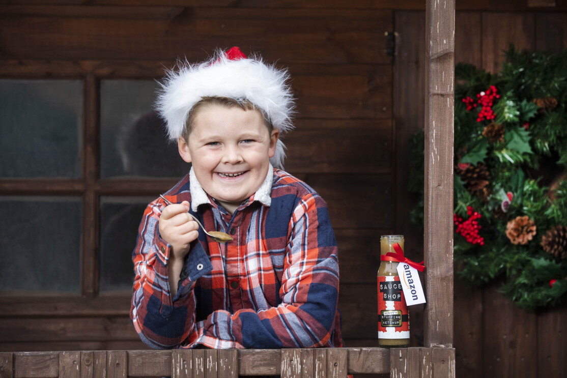 Berty with stuffing sauce on a spoon, he is leaning on his porch and wearing a santa hat. 