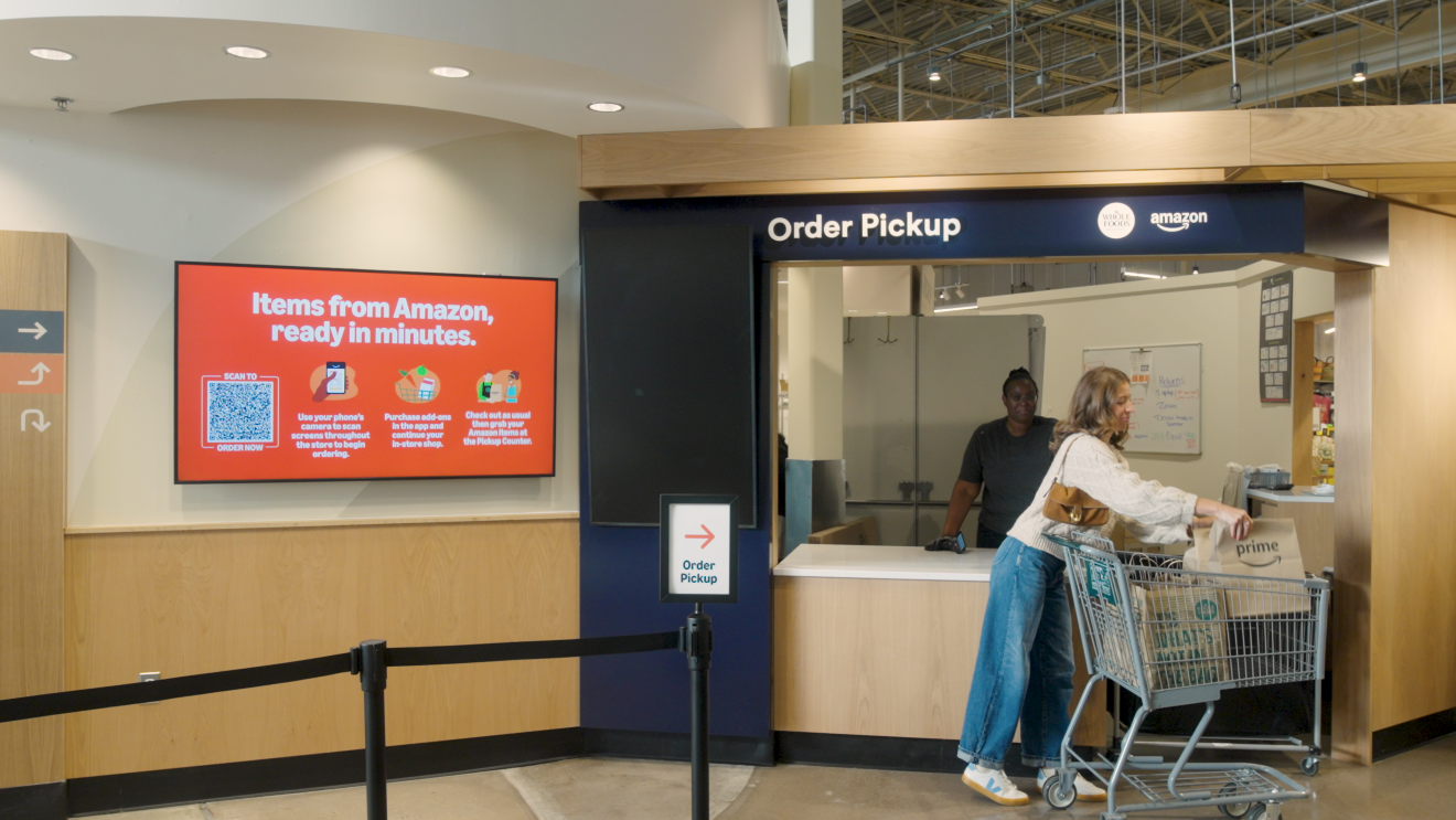 Customer with whole Foods and Amazon Prime bag grabs items from the counter