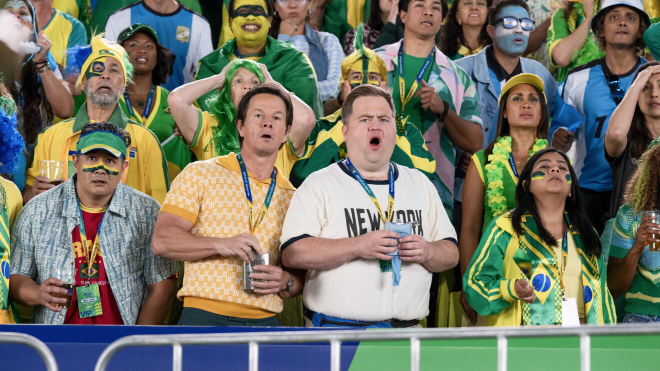 Colorful crowd at Brazil sporting event with passionate supporters, Mark Wahlberg at center