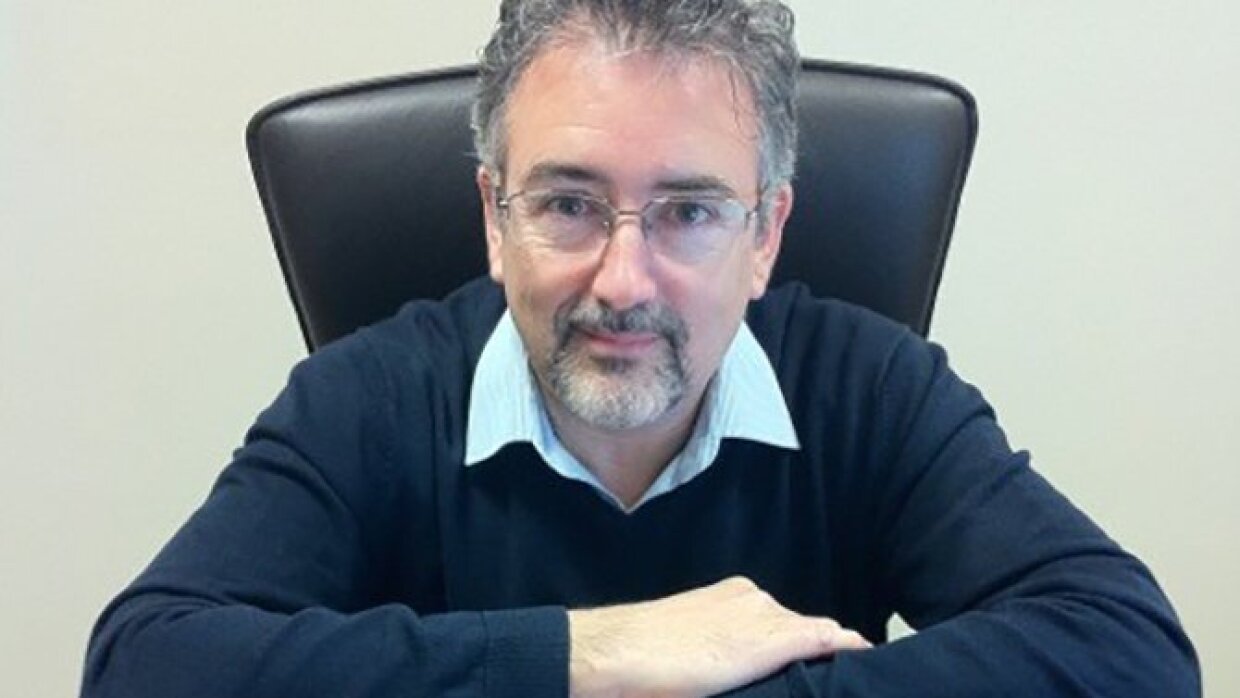 Portrait en buste de Nicolas Velle, assis sur un fauteuil en cuir et les bras croisés sur un bureau