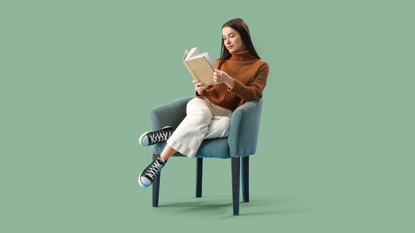 An image of a woman sitting in a chair reading a book.