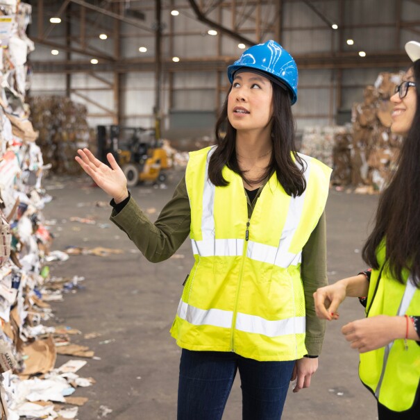 Two women stand at a recycling centre