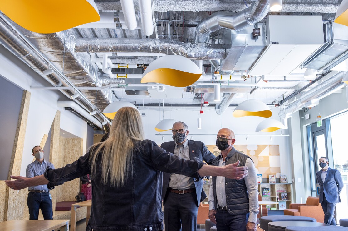 An image of the Mary's Place director greeting Gov. Inslee and Jeff Bezos as they walk into the shelter.