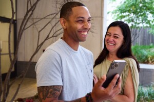 Craig Edwards and his partner, Stephanie, are pictured with huge smiles while looking at a notification on Edwards's phone stating that he's cancer-free.