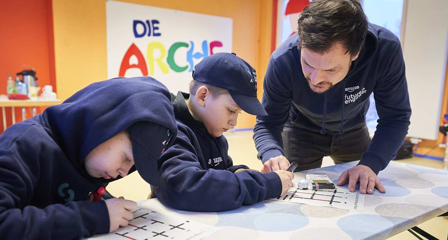 Arche Kinder mit Betreuer bei einem Coding-Workshop.