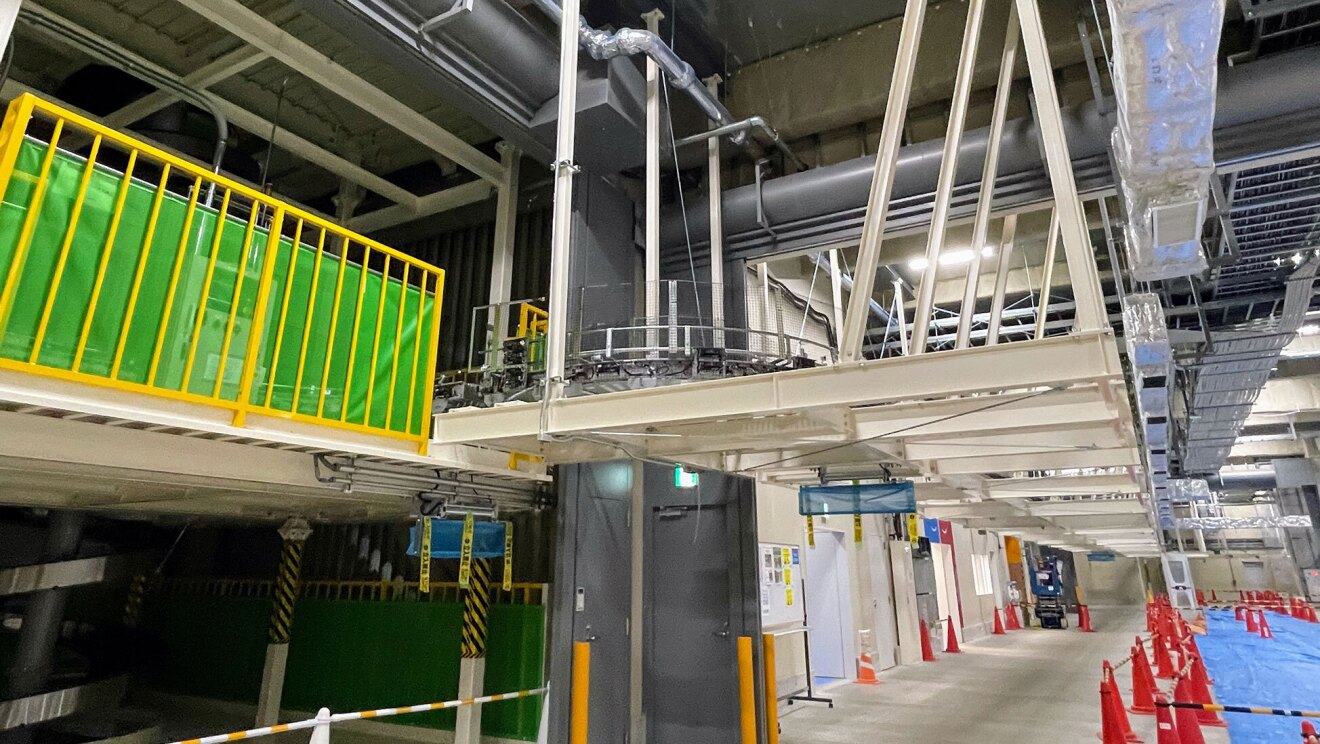 高い天井のあるフロアにコンベア用の中2階が設置され、人の通路と隔てられている