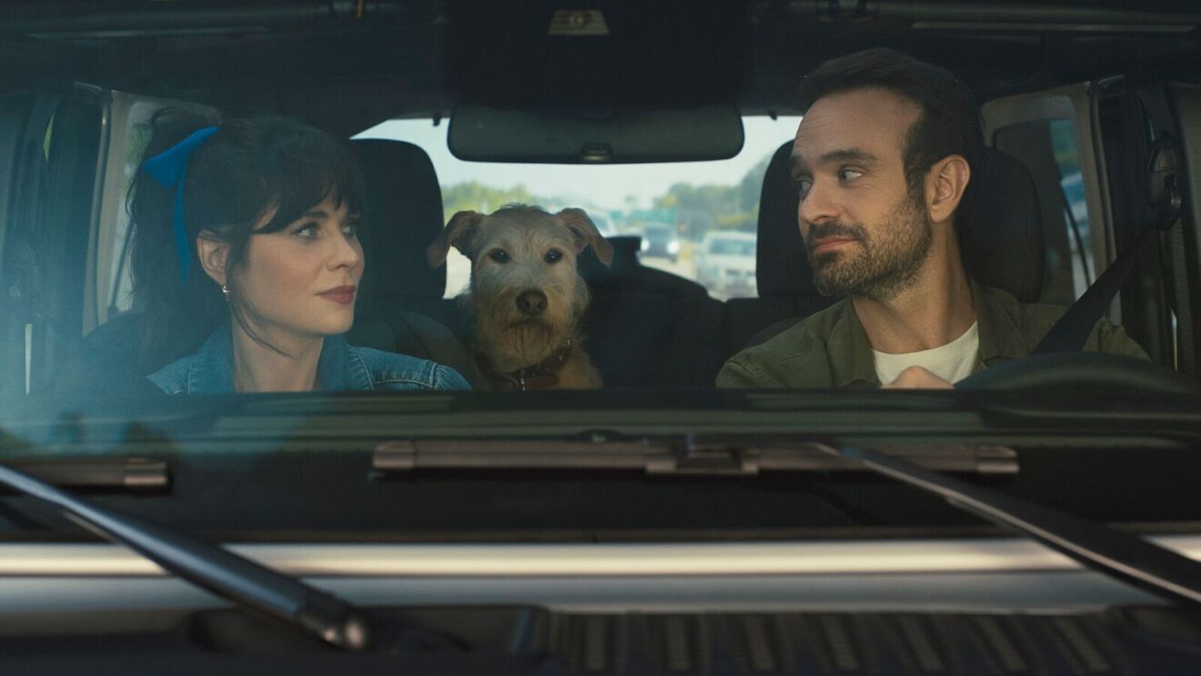 Couple and dog in car, woman in denim, man driving, terrier between them