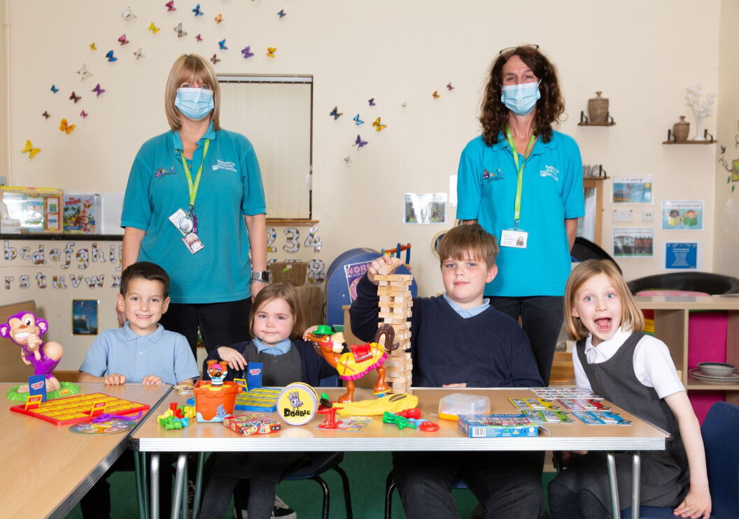 Barnardos Partnership, volunteers with students, in front of them is a table full of games.