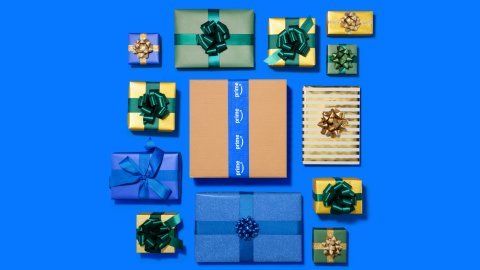 Boîtes et paquets cadeaux colorés disposés sur fond bleu vif