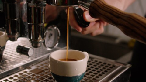 Freshly brewed coffee flowing into a ceramic cup