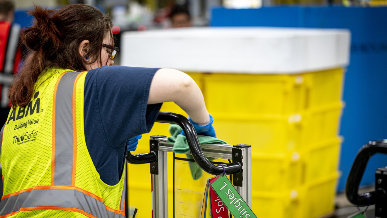 Kobieta wyciera maszynę w centrum logistycznym Amazon.