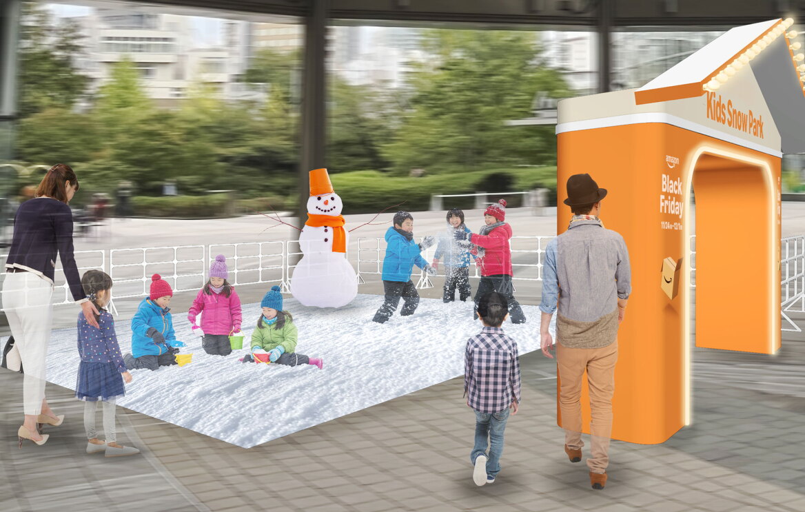 屋外につながった広い空間に、白い柵で区切られた人工雪の遊び場が設置されている。雪の上に雪だるまと、遊ぶ子どもたち。右側にオレンジ色のアーチ。2組の親子連れが雪の外側から眺めている。
