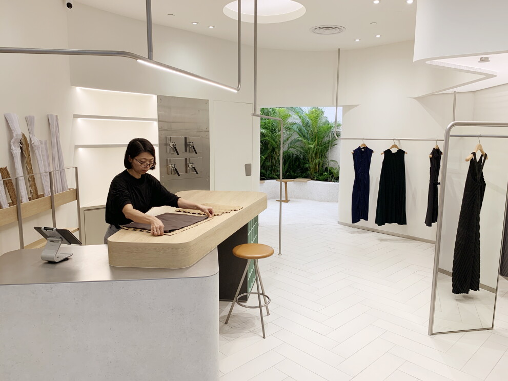 Gin is seen folding pleated cloth together at the GINLEE store.