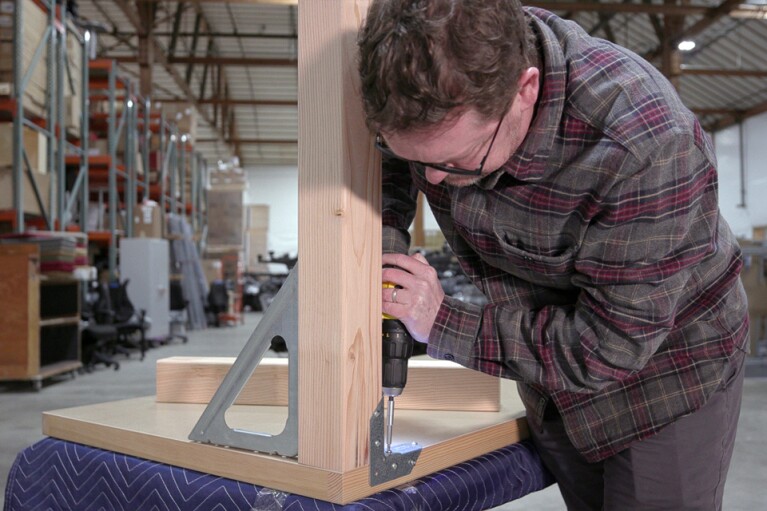Amazon employee Nico Lovejoy builds a door desk.