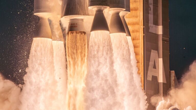 Nahaufnahme der zündenden Triebwerke eines Raumschiffs, umgeben von wogenden Abgasen