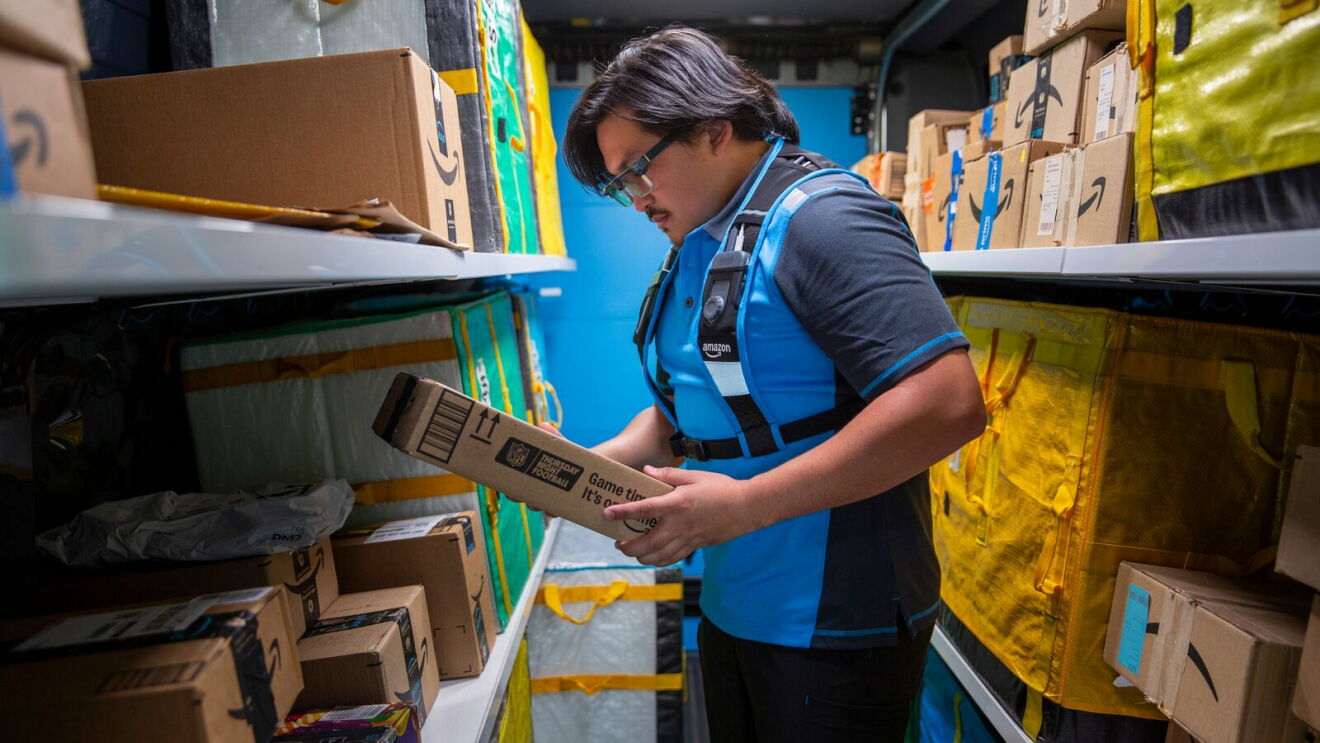 Amazon driver wears smart glasses and stands in a delivery vehicle