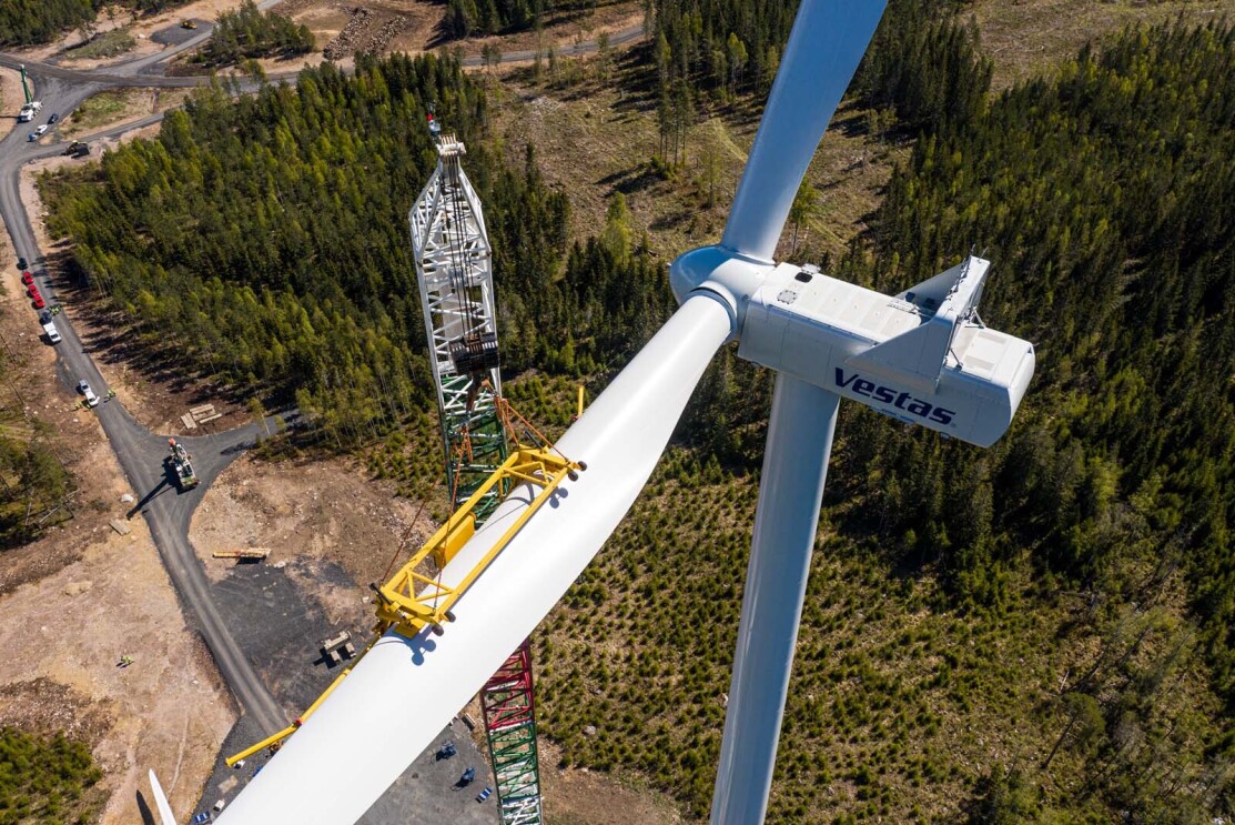 Birds-eye view looking down on a crane assembling a wind turbine.