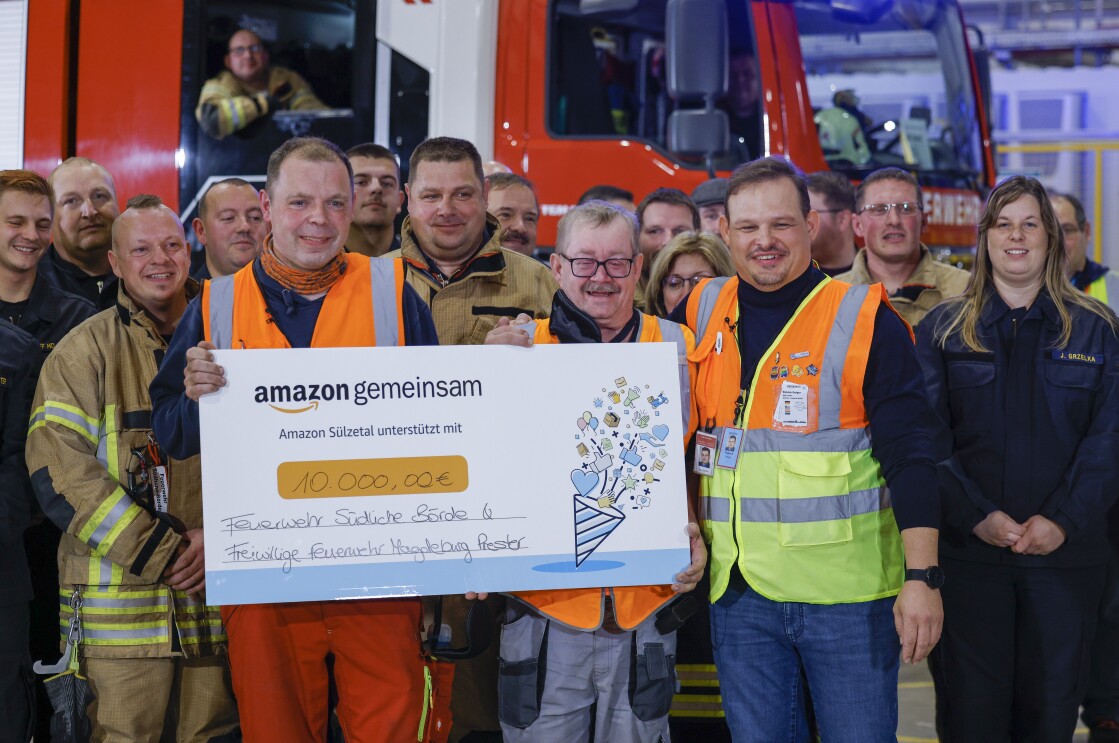 Alex und Uwe werden im Amazon Logistikzentrum Sülzetal von Kolleginnen und Kollegen sowie von ihren Kameraden der frewilligen Feuerwehr mit der Amazon Star Auszeichnung überrascht.