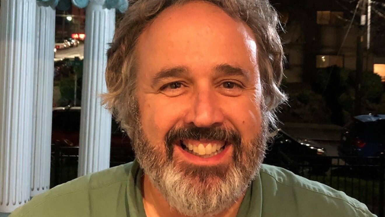 Headshot of Gus Lopez in a khaki shirt