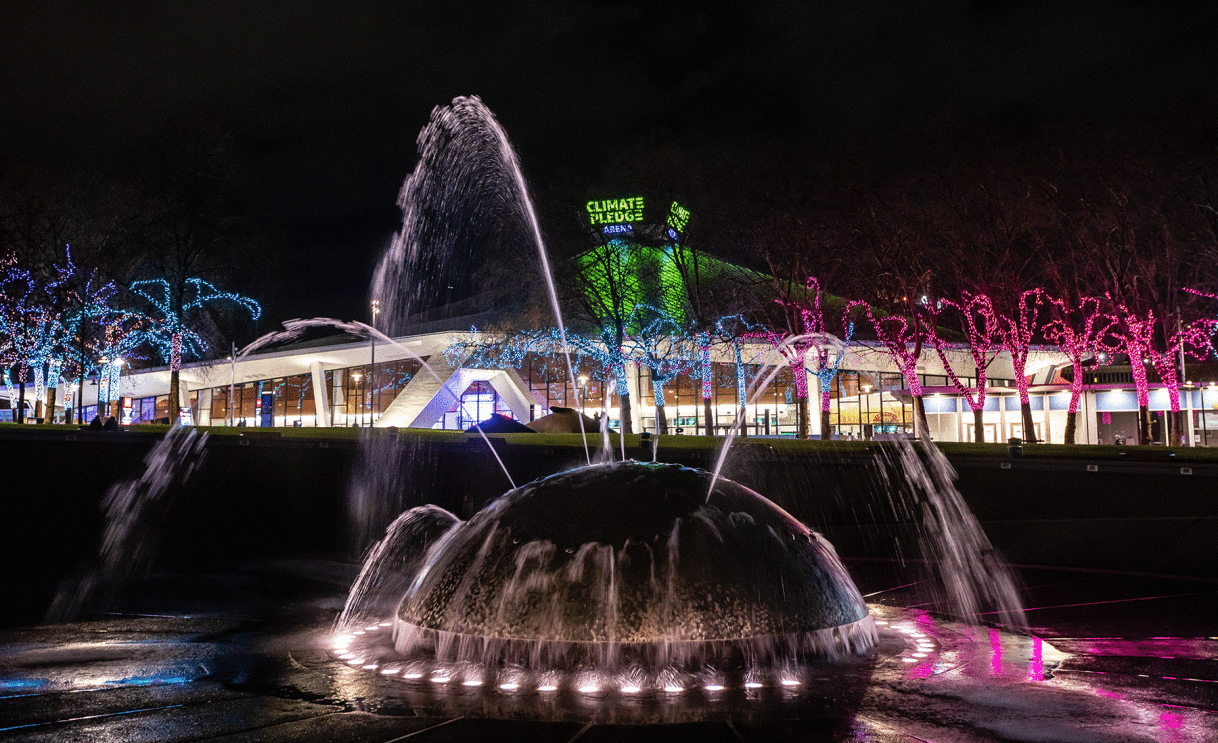 An image of holiday lights surrounding the Climate Pledge Arena at night.