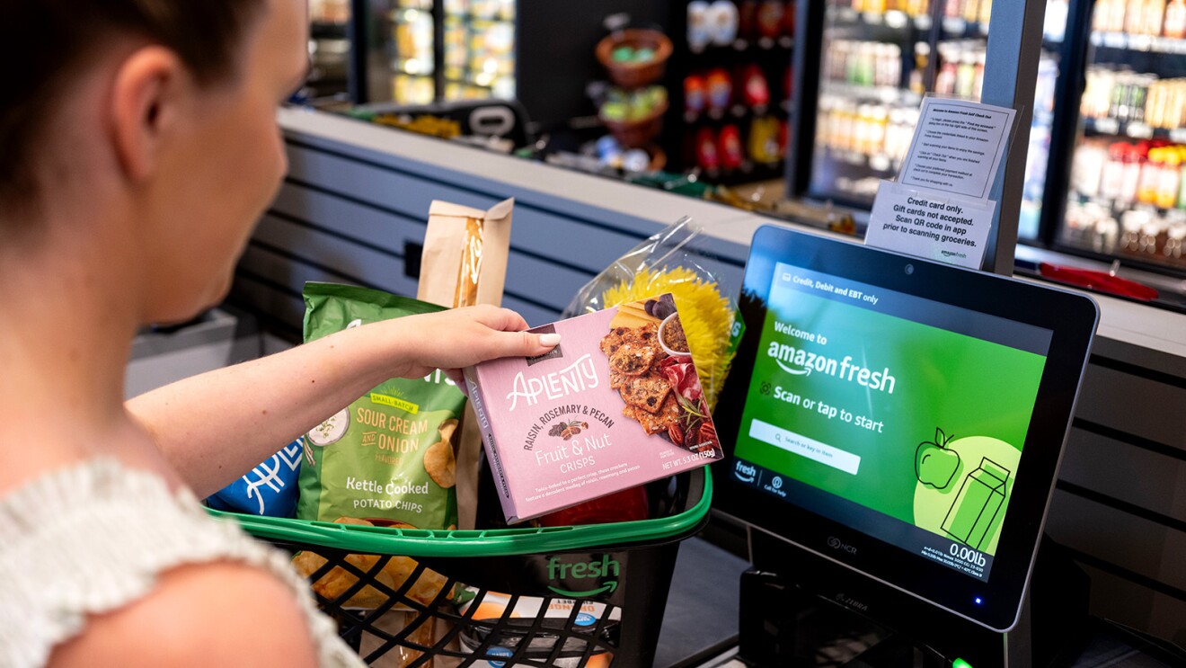 A photo of a customer using the self checkout at an Amazon Fresh store.