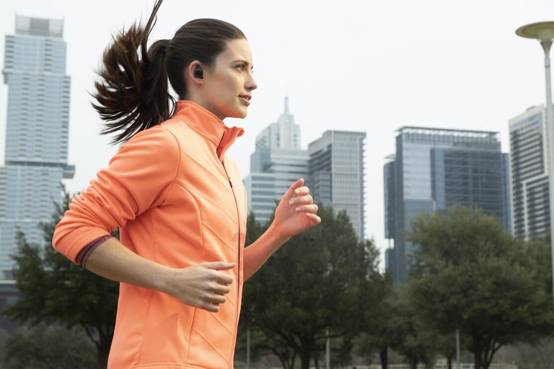 A woman running on a street wearing Echo Buds