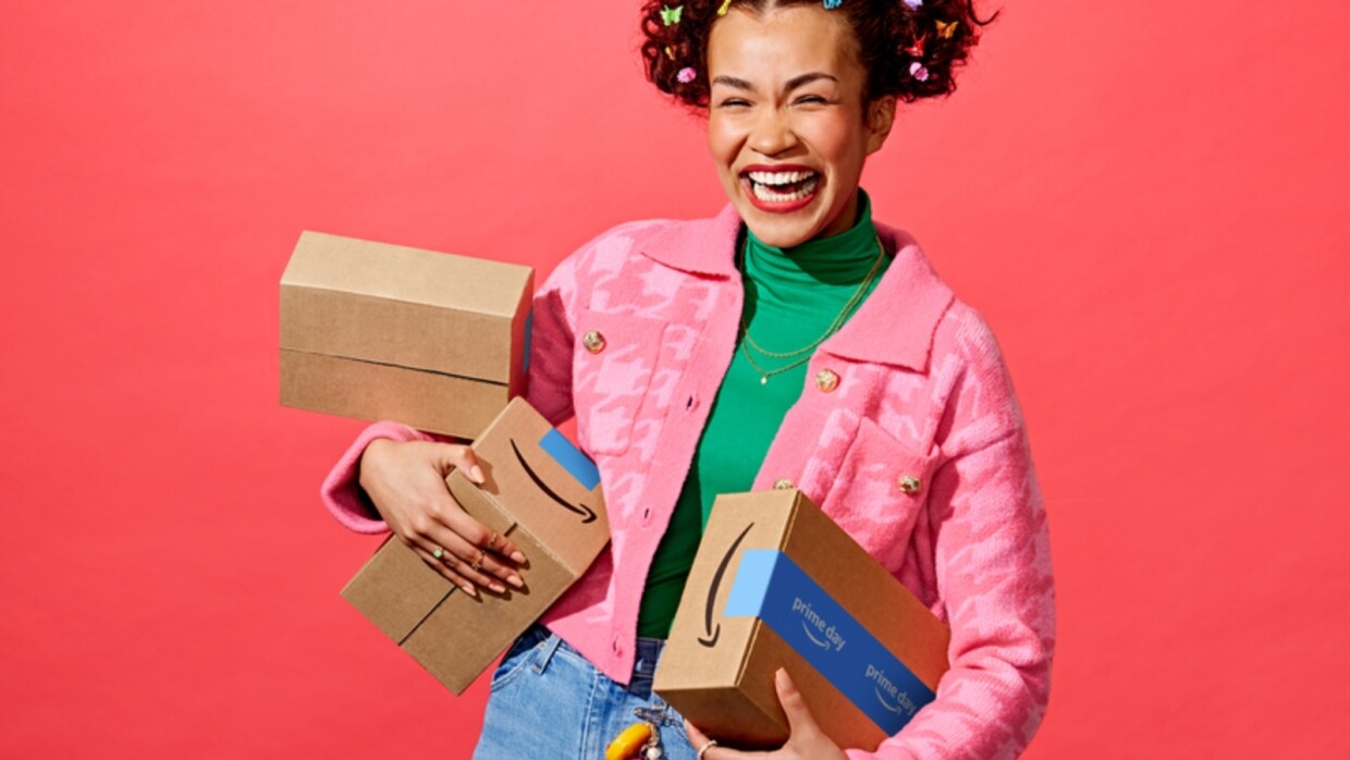 Prime Day 2023 Launch, happy shopper smiling and carrying three parcels.