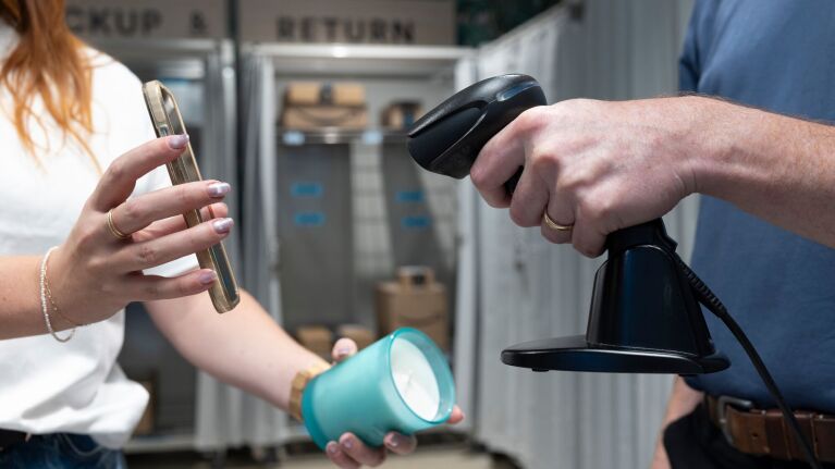 Hands scanning product with barcode reader with Amazon's no shipping box, tape, or label needed return service