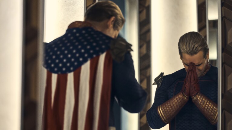 Soldier holding American flag, comrade praying with hands clasped