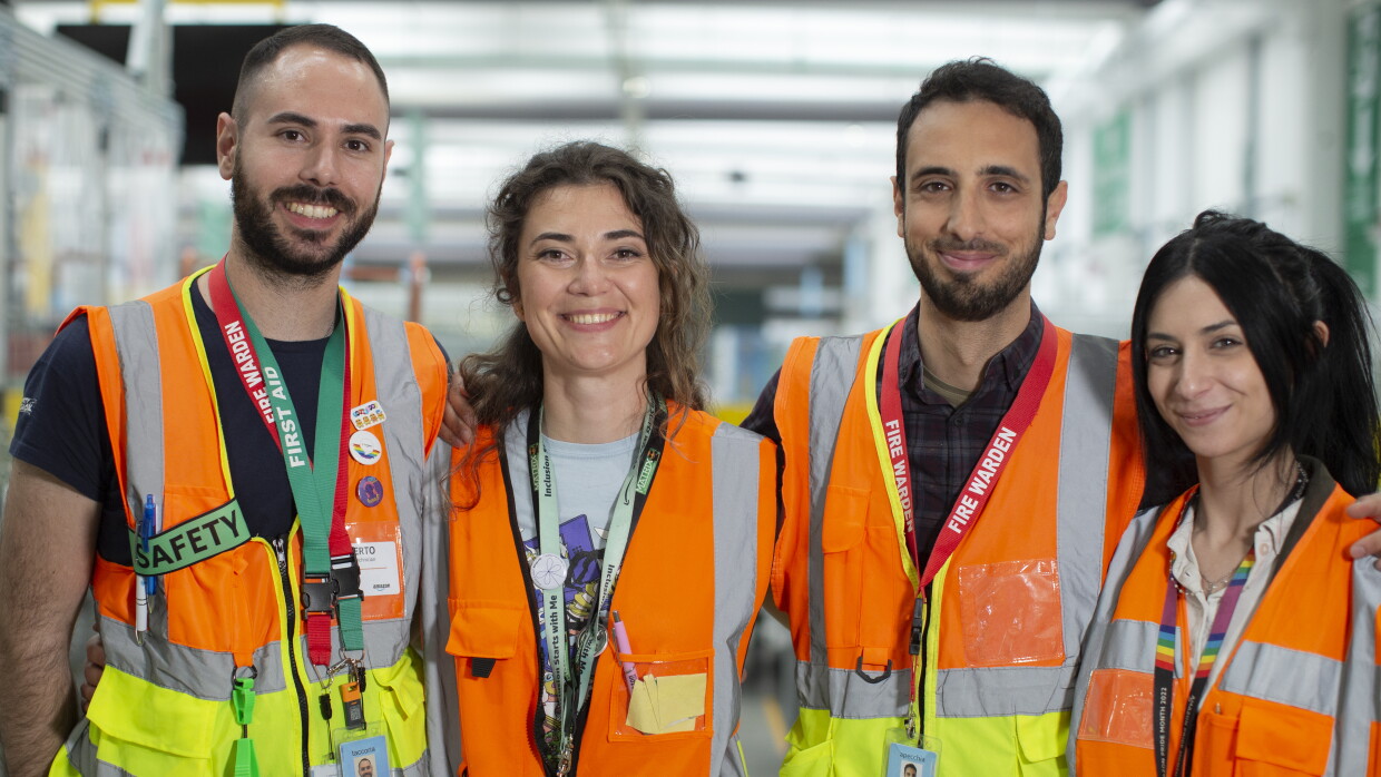 Team safety DLO1: four young men and women in orange vests are smiling at the camera