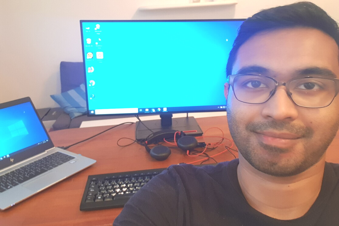 Selfie photo of a man sitting in front of a desk with a computer on it.
