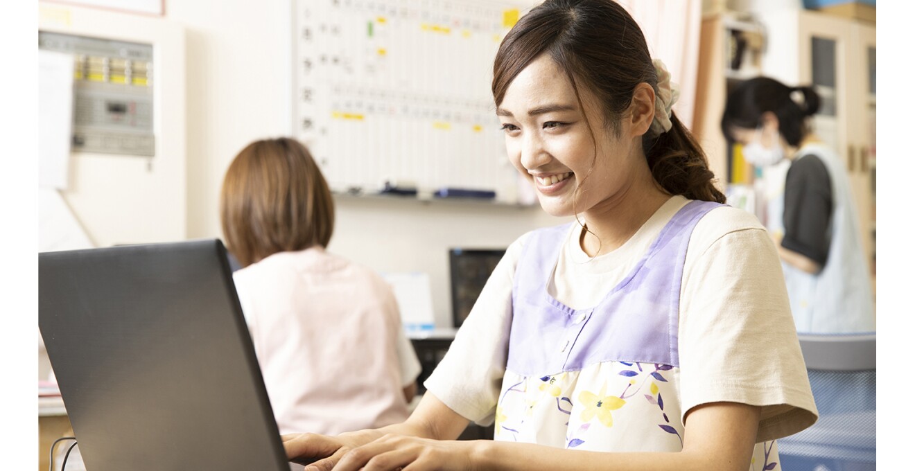 ノートパソコンで仕事中の保育園の職員さん