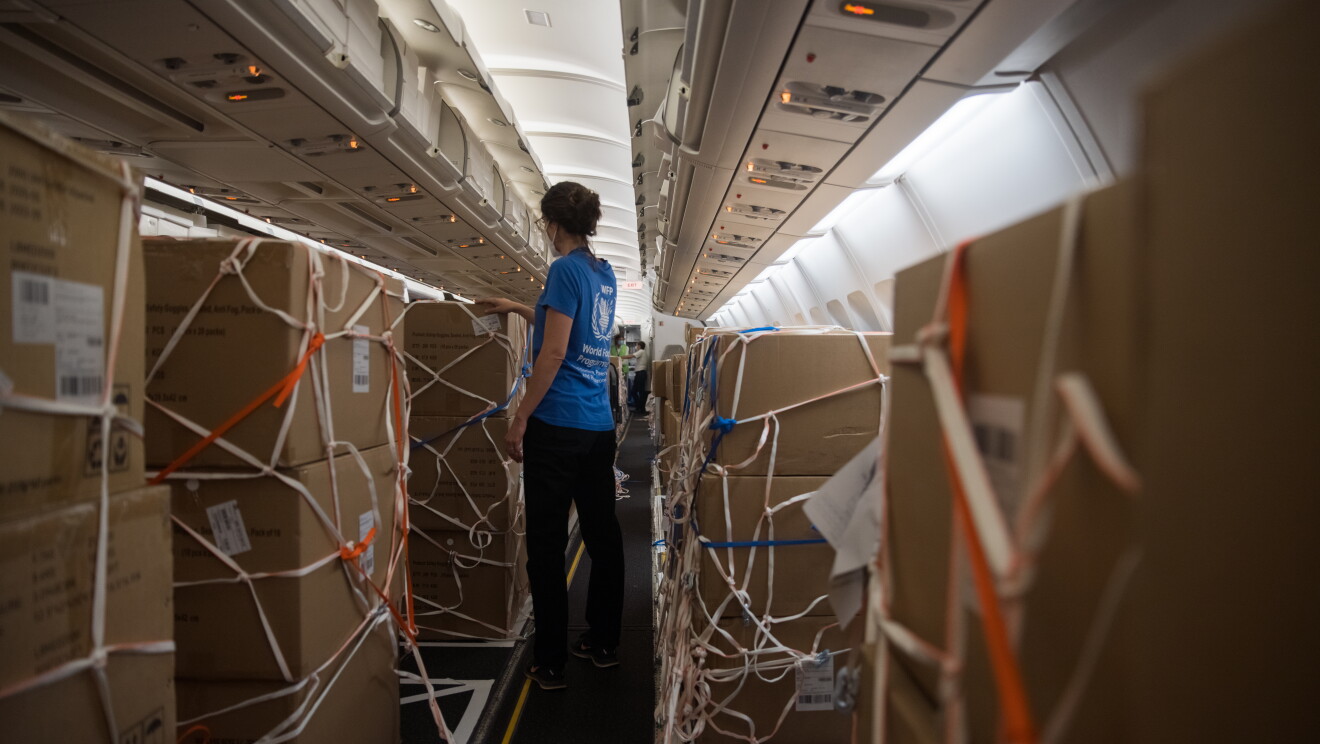 Supply crates in the plane with someone checking them.