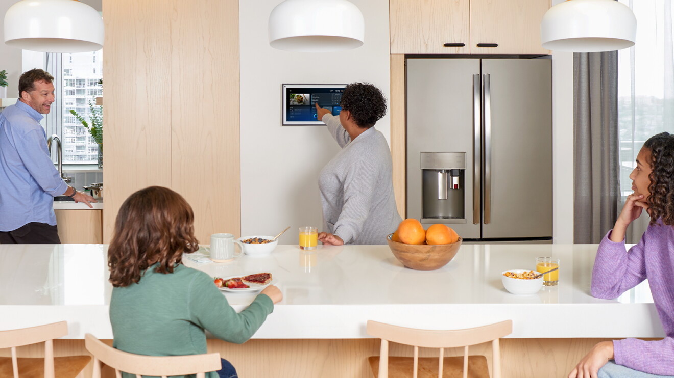 Family of four around a kitchen table interacting with Alexa+