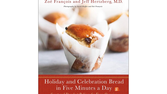 一本假日烹饪书,羊皮纸包装的庆祝面包,前面是其他面包店的点心。