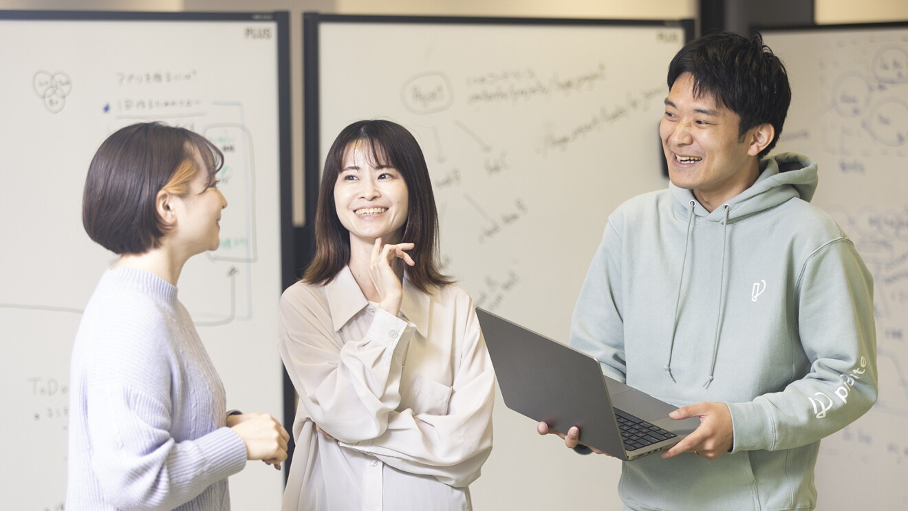 オフィスで会話をしている女性二人と男性1人