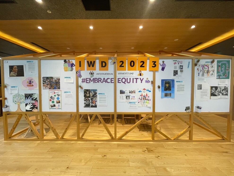 木製の掲示パネルにIWD2023の文字。周囲に写真やポスターなどが貼られている