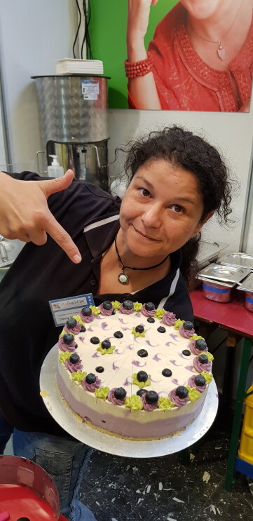 Christin mit Kuchen in der Küche - und mit Pfanne im Logistikzentrum
