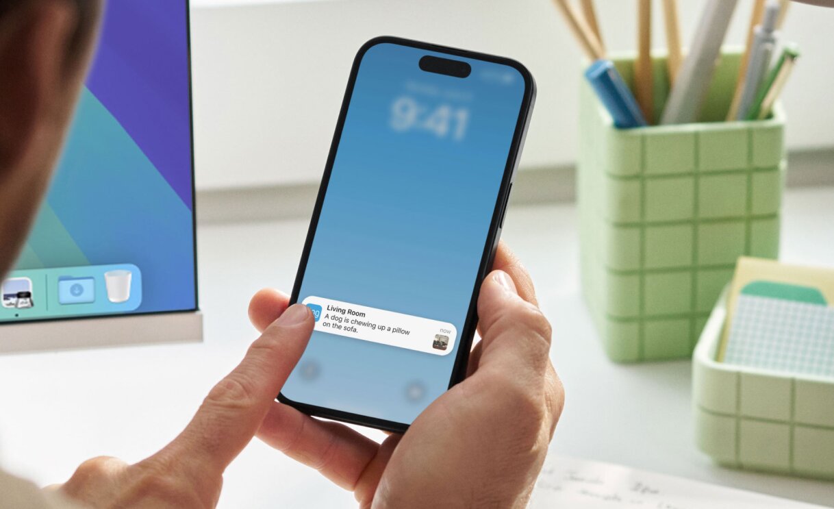 Hands holding iPhone displaying 'Living Room' reminder notification