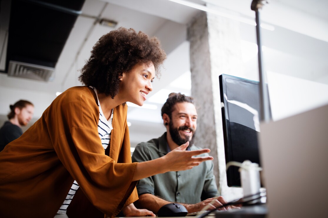Two people in discussion looking at a computer screen