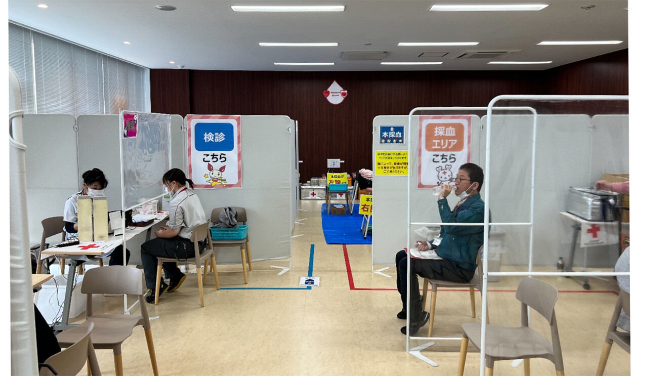 パーテーションで区切られた臨時の献血会場に参加者が並ぶ写真