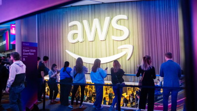 re:Invent visitors at Amazon Web Services with illuminated signage and purple ambient lighting