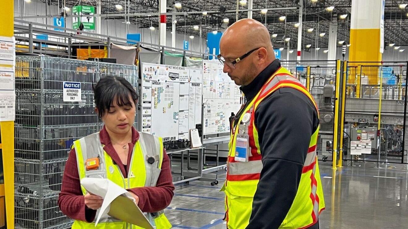 An image of a woman and man dressed in yellow work vests.