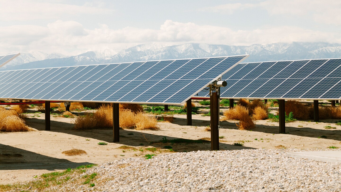 Large-scale solar farm set against rugged mountain scenery