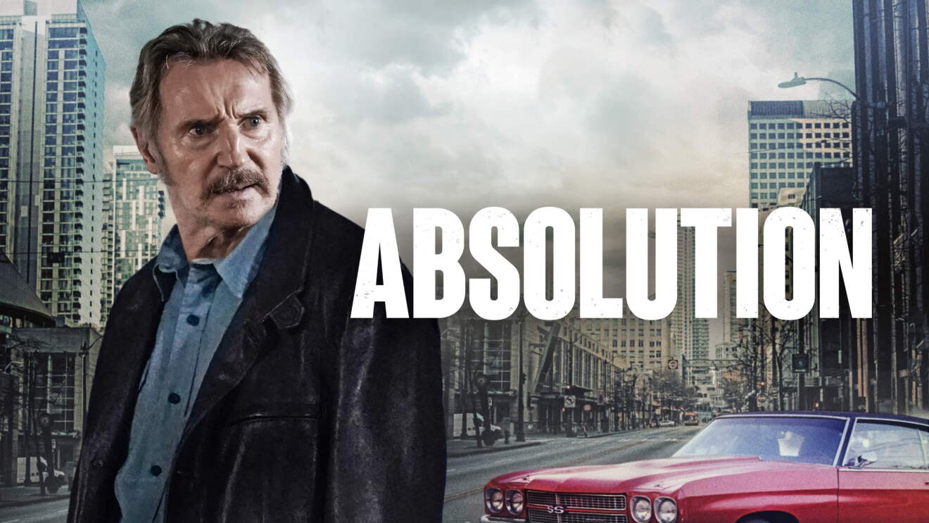 A man in jeans shirt and black jacket is looking angry in front of a city