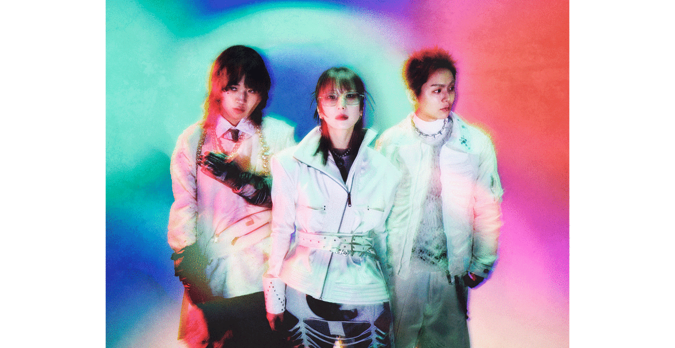 水色やピンク、青がまじりあう背景に、3人の人物が立っている。3人とも白い衣装を着用。左側と中央の2人のボトムは黒。