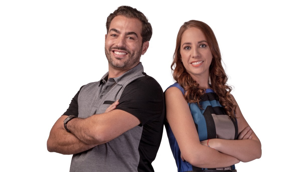 Santiago Lichi and Regina Velasco, co-founders of By México, stand back-to-back smiling.