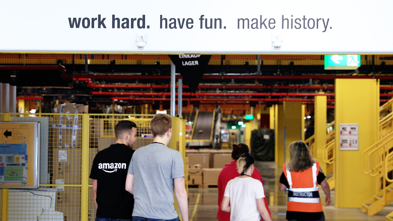 Das Team von Amazon Frankenthal im Logistikzentrum unter dem Banner: work hard. have fun. make history.