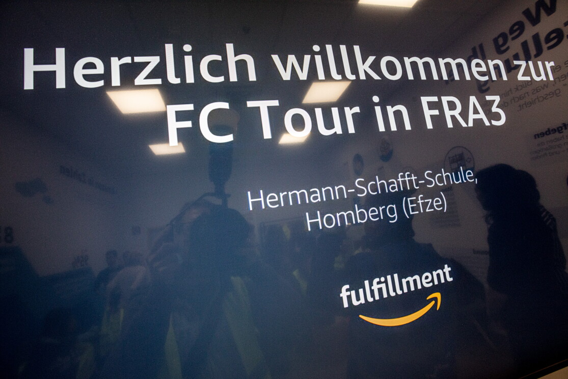 Ein Willkommensschild für die BesucherInnen mit weißer Schrift auf blauem Hintergrund.