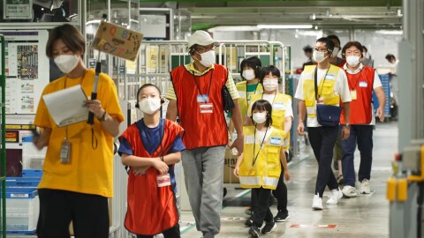 FCツアーの旗を掲げたコンダクター役のスタッフに続き、FC内を見て歩く参加者たち